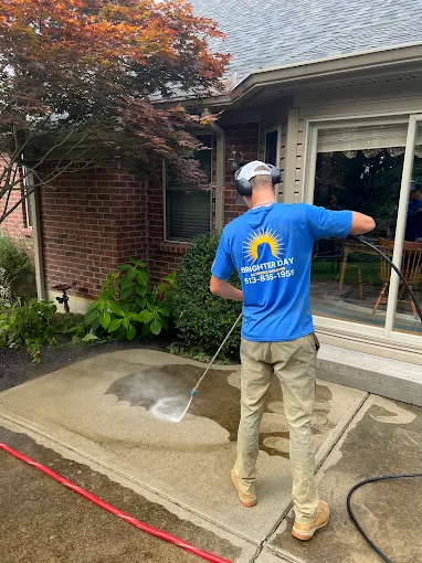 Pressure washing service cleaning a concrete driveway in Cincinnati OH by Brighter Day Exterior Cleaning